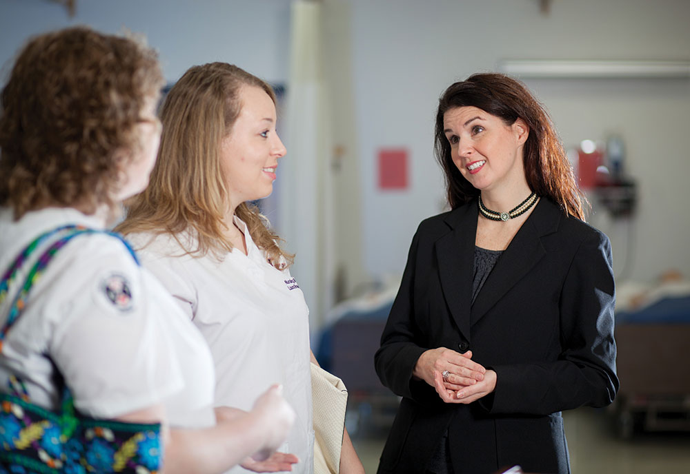 Assistant nursing professor Kathy Miller speaks with students Catherine Thomas (left) and Brooke Priest. 