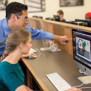 Jerry Falwell Library customer service specialist Isaac Arias assists Abigail Kouns with an Adobe program.