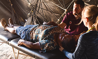LUCOM student-doctors perform Osteopathic Manipulative Medicine (OMM) on native woman from Guatemala; LUCOM Medical Outreach 2016.